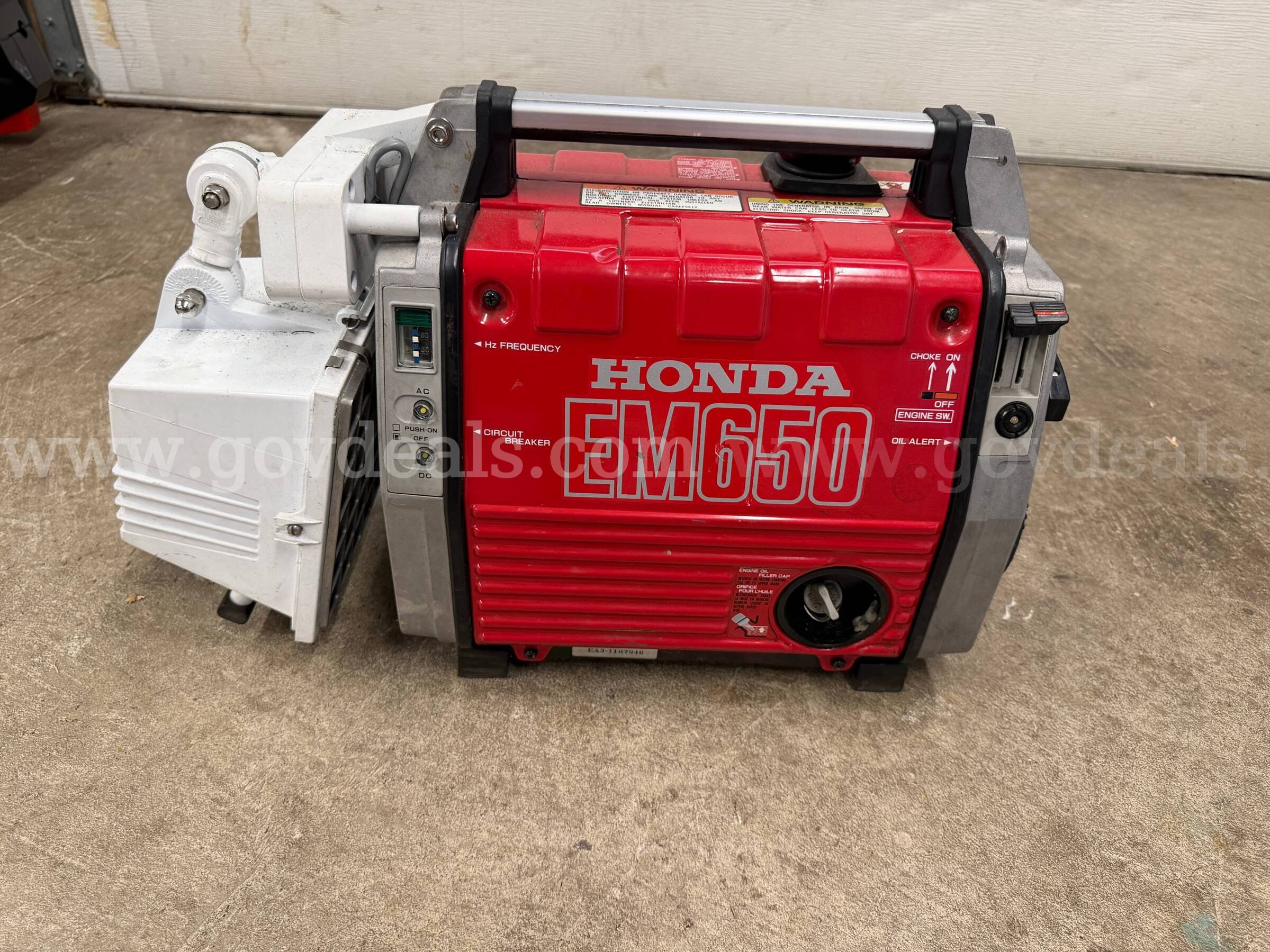 Portable gas generator with attached light Honda EM650 Government Surplus Auction - Primary Photo