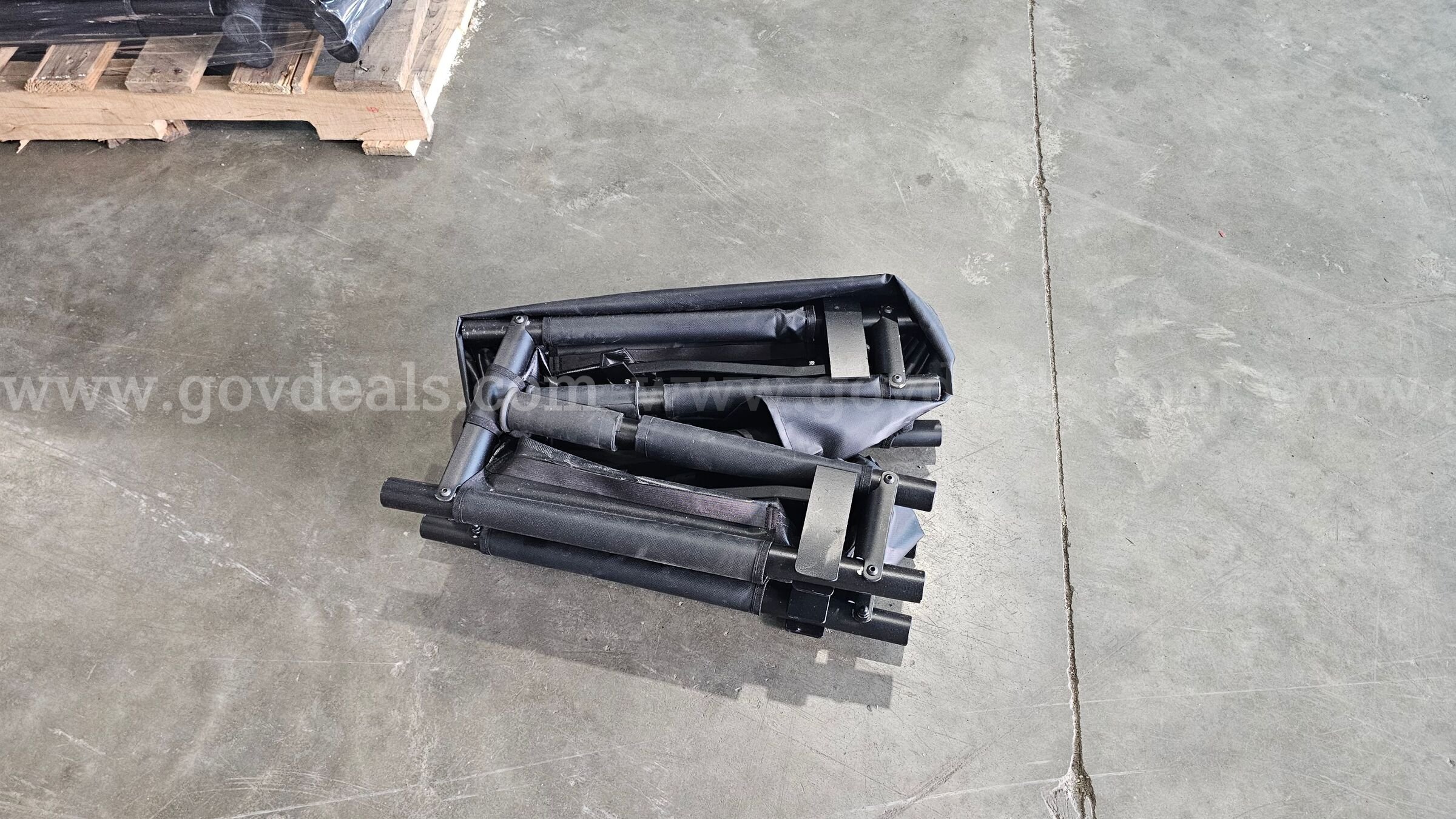 pallet of approximately 30 black folding Military style field stretchers.   Government Surplus Auction - Photo #3