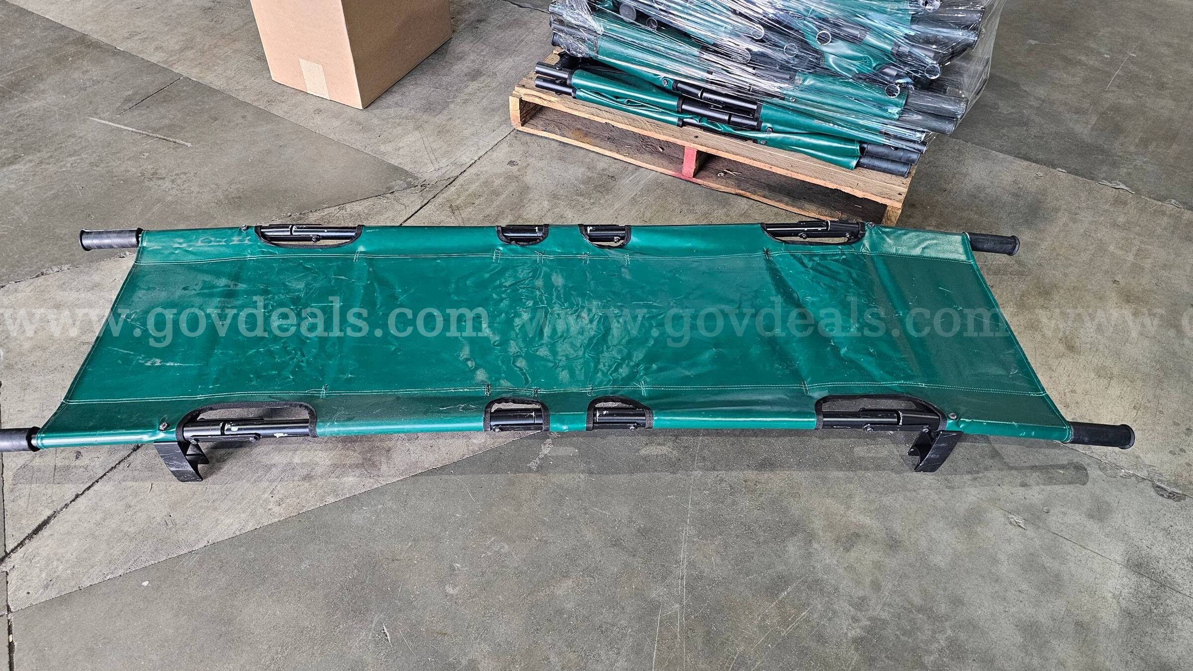 pallet of approximately 25 green folding Military style field stretchers.