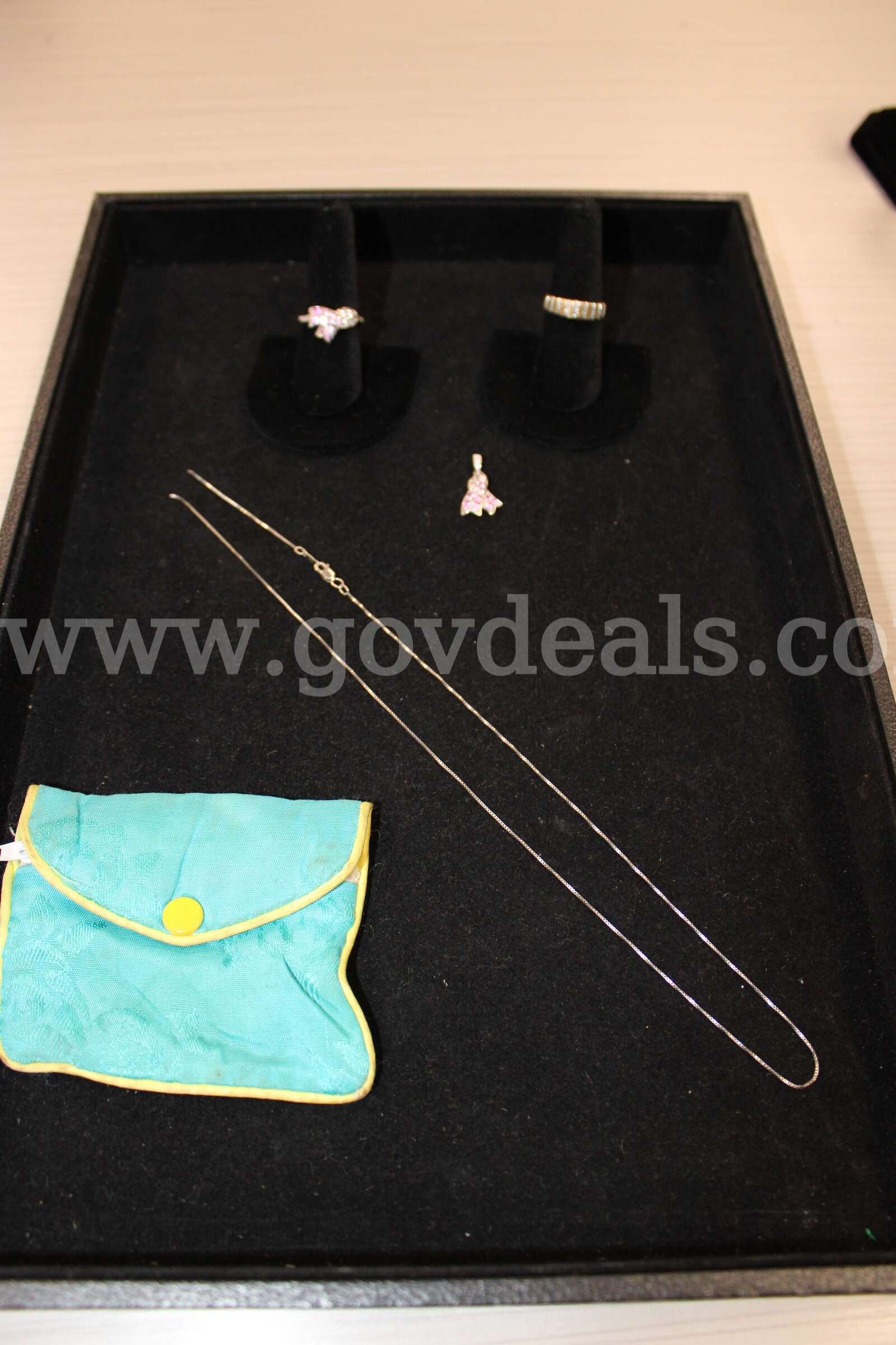 Necklace (1)  Charm (1) Ring (2) Pouch (1)   Government Surplus Auction - Primary Photo